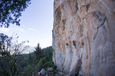 Güçlü bir adam kayaya tırmanır, güçlü sırt kasları, Türkiye 'de kaya tırmanışı, dayanıklılık ve güç eğitimi alır, ekstrem sporlarda çalışan bir adam, dağcı doğada eğitim görür..