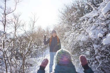 Bir çocuk annesiyle kartopu oynar, bir kadın oğluyla karlı bir ormanda oynar, kış eğlencesi, bir kadın çocuğuyla kış parkında yürür..