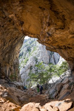 Kaya tırmanışı doğal arazide. Tırmanışçılar bir rota seçer. Arkadaşlar ekstrem sporlara gider. Takım çalışması. Kemer şeklinde bir kaya. Mağarada tırmanma rotası.