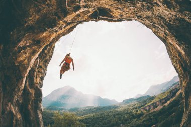 Kaya tırmanışçısı ipte sallanıyor. Bir kadın kemer şeklinde bir kayaya tırmanıyor. Kız mağaraya tırmanıyor. İpi bağlamak için tırmanma ipi. Türkiye 'de kaya tırmanışı .