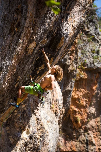 若いアスリートが岩に登り 自然の地形で登山家が訓練し 男は強さと持久力を訓練し 子供とティーンエイジャーのための岩登り — ストック写真