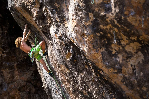 一位年轻的运动员爬上岩石 一位登山者在自然的地形上训练 一位男子训练力量和耐力 一位儿童和青少年攀岩 — 图库照片