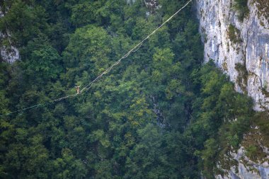 Dağlarda yüksek bir yer. Bir adam askı takıyor. Highline çizgide. Bir ip cambazı dengeyi yakalar. Eşitlik. Gergin bir durumda güven.