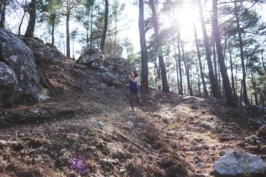 Bir kadın dağ yolunda koşuyor. Koşucu ormanda antrenman yapıyor. Parkta koşan bir kız. Skyrun.