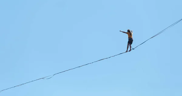 一个人在蓝天的映衬下沿着高地走着 远洋班轮在一条伸展的吊带上前进 紧凑型步行者 男人能保持平衡 — 图库照片