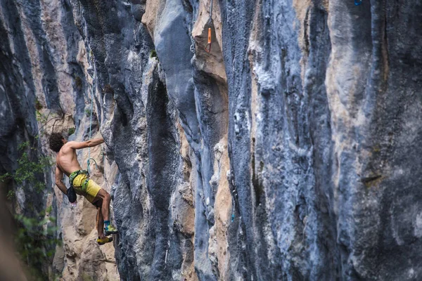 A strong man climbs a rock, Strong back muscles, Rock climbing in Turkey, Training endurance and strength, man in extreme sport, Rock climber is training in nature.