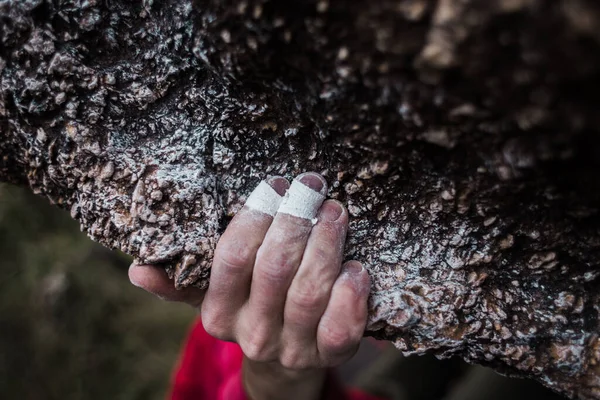 the hand of a strong climber holds onto a rock on a difficult route. sports and healthy lifestyle.