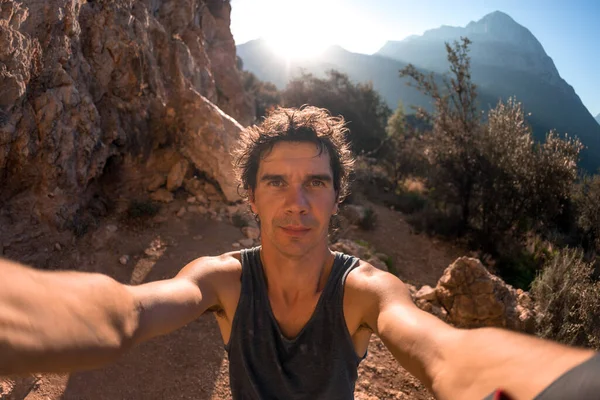 Bir adam güzel bir dağ vadisinin ve kayaların arka planında selfie çeker, Türkiye 'de resim gibi yerlerde seyahat eder, Türkiye Kayaları, Kaya tırmanışı.