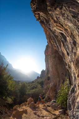 Bir kız eğitim sırasında bir erkek dağcıyı sigortaladı. Doğada aile tatili. kaya tırmanışı bir spor ve açık hava eğlencesi olarak