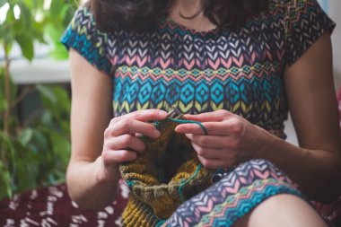 Kadın örgü örer. ev yünü kıyafetler. Boş zamanlarında, kız bir hobiyle meşgul oluyor..