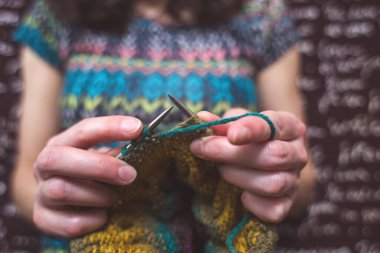 Kadın örgü örer. ev yünü kıyafetler. Boş zamanlarında, kız bir hobiyle meşgul oluyor..