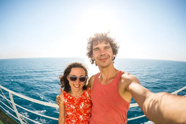 The family is sailing on a cruise ship, a woman with husband are standing at the fence on the ship and looking at the sea, traveling by ferry, a man with girlfriend take selfies on the ocean.