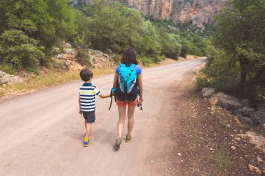 Sıcak mevsimde dağlarda ve ormanlarda yürüyüş. Anne ve çocuk dağlarda yürüyüşe çıktılar. bir çocukla aktif hafta sonu.