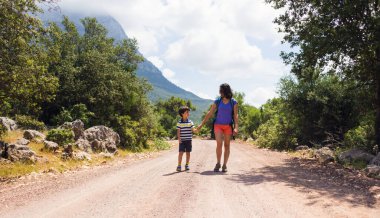 Sıcak mevsimde dağlarda ve ormanlarda yürüyüş. Anne ve çocuk dağlarda yürüyüşe çıktılar. bir çocukla aktif hafta sonu.
