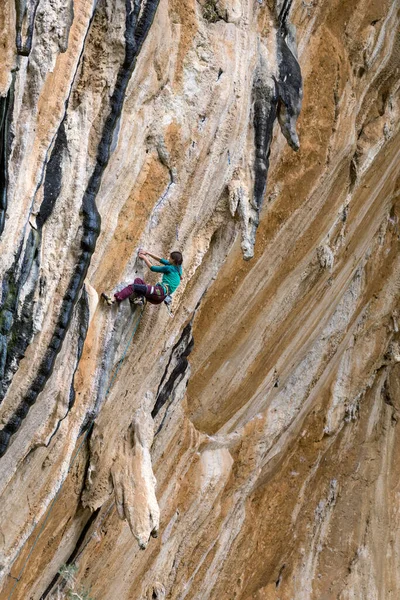 一个女人爬上殖民地上的岩石 一个苗条的女孩克服了艰难的攀登路线 攀登者在自然地形上训练 健康的天性 极端的嗜好 是的土耳其Datca地区的攀岩 — 图库照片