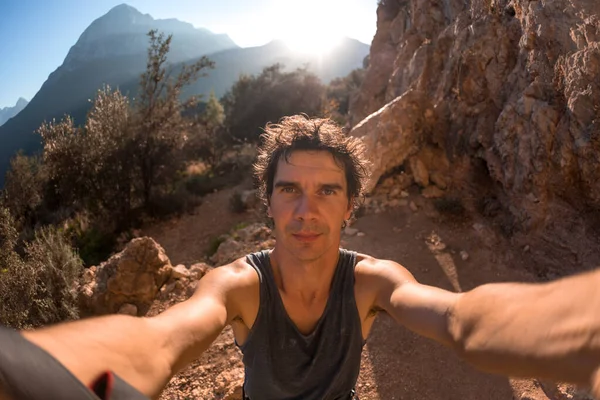 Bir adam güzel bir dağ vadisinin ve kayaların arka planında selfie çeker, Türkiye 'de resim gibi yerlerde seyahat eder, Türkiye Kayaları, Kaya tırmanışı.