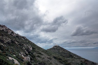 Datca 'daki antik deniz feneri, Türkiye kıyıları, deniz arka planında deniz feneri ve bulutlu gökyüzü, Türkiye manzarası