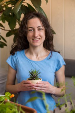 Bir kadın elinde sulu bir tencere tutuyor, bir kız çiçek satıyor, satılık bitkiler yetiştiriyor, hediye olarak bir bitki, bir serada çiçekler, saksı bitkisi..