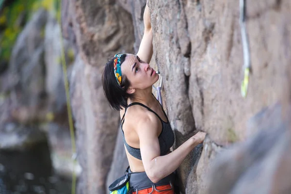 少女は岩の上をロッククライミングしようとします 女子登山家は困難な道を登り — ストック写真