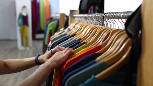 Chica Una Tienda Ropa Una Mujer Elige Una Camiseta Una — Vídeos de Stock