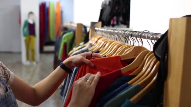 Chica Una Tienda Ropa Una Mujer Elige Una Camiseta Una — Vídeos de Stock