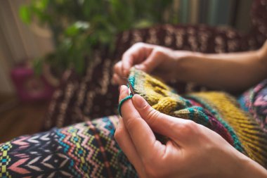 Kadın örgü örer. ev yünü kıyafetler. Boş zamanlarında, kız bir hobiyle meşgul oluyor..