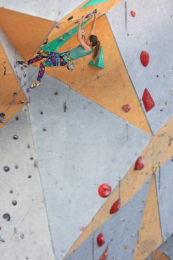 Kaya tırmanışçısı rotayı tırmanır. Ekstrem sporlar için şehrin duvarına tırmanmak.