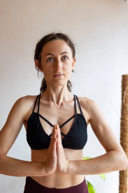 sağlıklı ve güzel vücut konsepti. Güzel esmer kadın meditasyon yapıyor, evde yoga yapıyor. Formda ve sağlıklı kalmak.