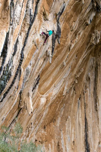 一个女人爬上殖民地上的岩石 一个苗条的女孩克服了艰难的攀登路线 攀登者在自然地形上训练 健康的天性 极端的嗜好土耳其Datca地区的攀岩 — 图库照片