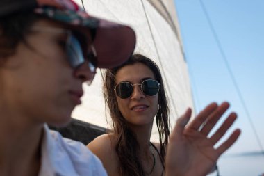 Kızlar bir yatta dinleniyor, iki gülümseyen kadın bir yatta eğleniyor, yaz tatili, suda bir parti..