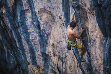Güçlü bir adam kayaya tırmanır, güçlü sırt kasları, Türkiye 'de kaya tırmanışı, dayanıklılık ve güç eğitimi alır, ekstrem sporlarda çalışan bir adam, dağcı doğada eğitim görür..