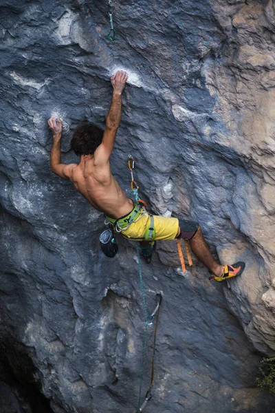 A strong man climbs a rock, Strong back muscles, Rock climbing in Turkey, Training endurance and strength, man in extreme sport, Rock climber is training in nature.