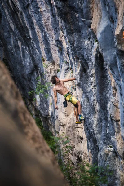 A strong man climbs a rock, Strong back muscles, Rock climbing in Turkey, Training endurance and strength, man in extreme sport, Rock climber is training in nature.