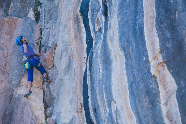 Μια Γυναίκα Κράνος Σκαρφαλώνει Έναν Όμορφο Μπλε Βράχο Αναρρίχηση Προστατευτικού — Φωτογραφία Αρχείου