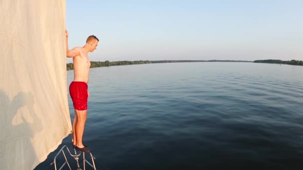 Man springt van een jacht in het water — Stockvideo