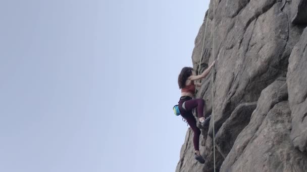 Beautiful girl climbs the rock. — Stock Video