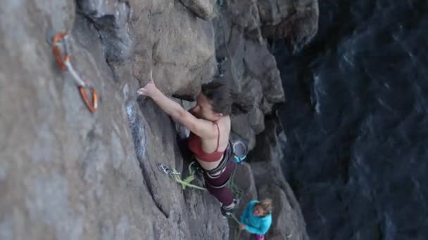 Gyönyörű lány mászik a szikla. — Stock videók