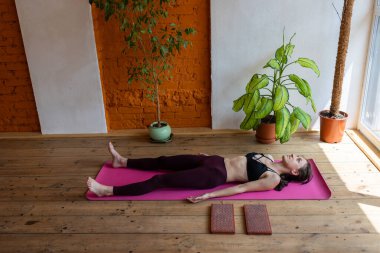 sağlıklı ve güzel vücut konsepti. Güzel esmer kadın meditasyon yapıyor, evde yoga yapıyor. Formda ve sağlıklı kalmak.