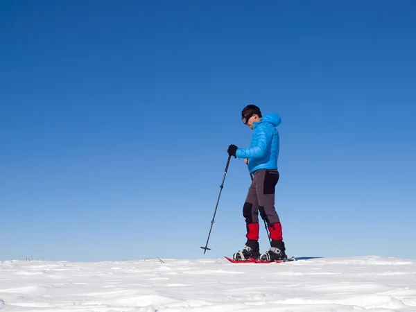 El hombre en raquetas de nieve en las montañas . — Foto de Stock