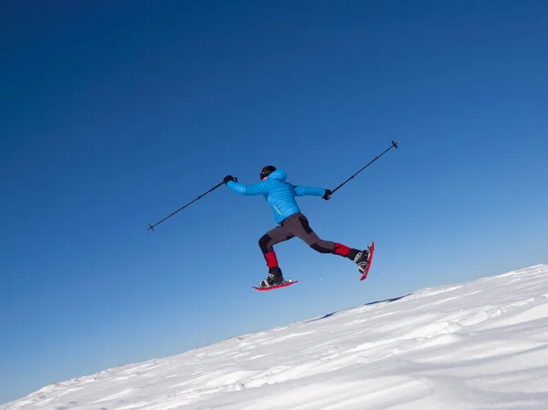 The man in snowshoes jumps in the mountains. — Stock Photo, Image