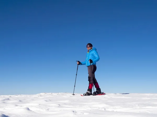 L'homme en raquettes dans les montagnes . — Photo