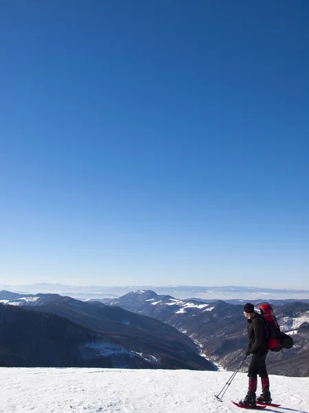 O homem de sapatos de neve nas montanhas . — Fotografia de Stock