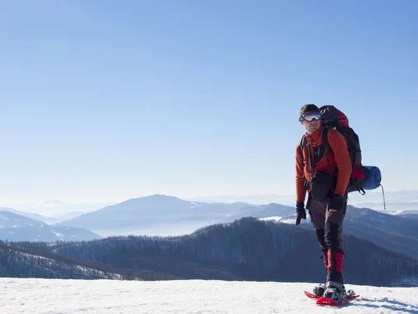 Der Mann mit den Schneeschuhen in den Bergen. — Stockfoto