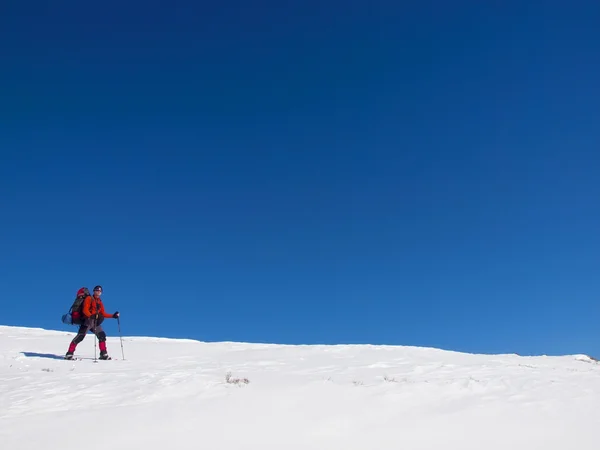 Mannen i snöskor i bergen. — Stockfoto