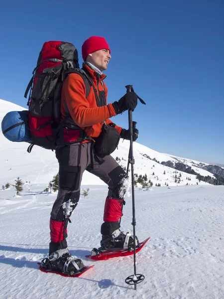 El hombre en raquetas de nieve en las montañas . — Foto de Stock