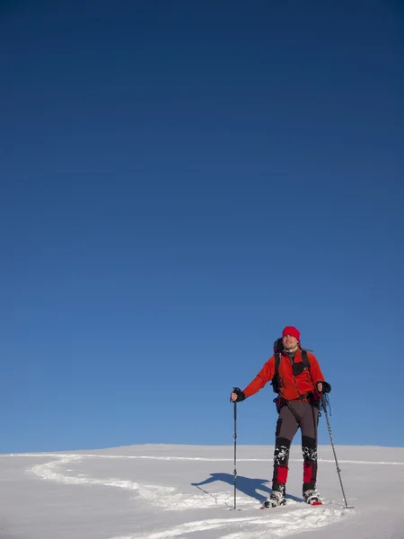 O homem de sapatos de neve nas montanhas . — Fotografia de Stock