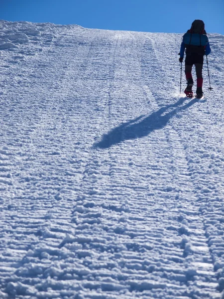 Mannen i snöskor i bergen. — Stockfoto