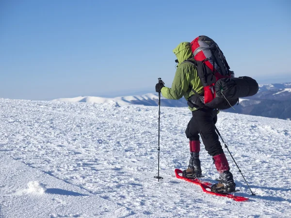 O homem de sapatos de neve nas montanhas . — Fotografia de Stock