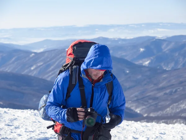 Men with a camera in the mountains in winter. — Stock Photo, Image