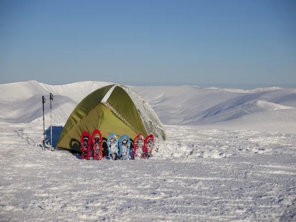 Снегоступы и палатки на снегу в горах . — стоковое фото
